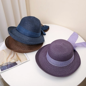 Women's straw beach hat with ribbon bow available in blue, brown and purple colors