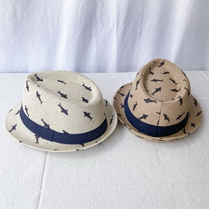 Detail of breathable straw fedora hats with blue shark patterns and ribbon trim