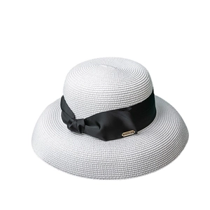 Women's wide brim straw sun hat with black ribbon bow and Memory gold logo tag
