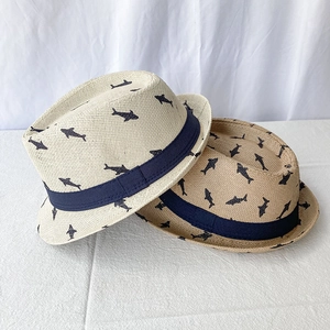 Detail of breathable straw sun hats with navy blue shark print and decorative ribbon