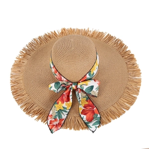 Wide brim straw sun hat with floral ribbon and fringe edges for beach vacation