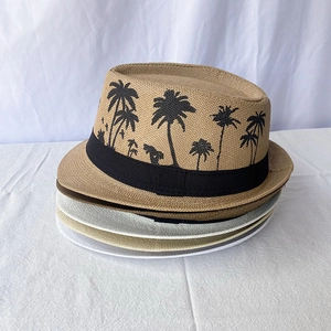 Close-up of stacked straw fedora hats featuring palm tree patterns and decorative ribbons