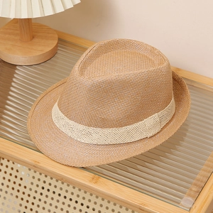Detail of classic brown straw fedora with woven band on a minimalist display stand