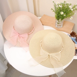 Elegante Strohhüte mit breiter Krempe, Perlenband und Organza-Schleife in Pink und Beige