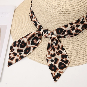 Close-up of fine woven straw hat with leopard print ribbon and stylish bow detail