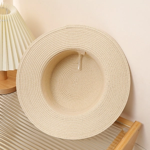 Detail of a beige woven straw hat with flat top and adjustable inner drawstring