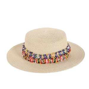 Women's flat top straw boater hat with vibrant colorful tassel trim and woven texture