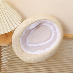 Detail of the breathable mesh lining and sweatband inside the cream straw sun hat