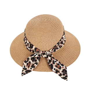 Women's wide brim straw sun hat with leopard print bow ribbon against a white background