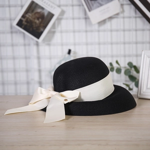 Detail of fine black straw weaving with a cream ribbon and large decorative bow