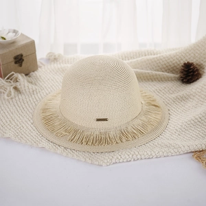 Beige woven straw hat with double fringe brim and metal logo tag for summer beach trips