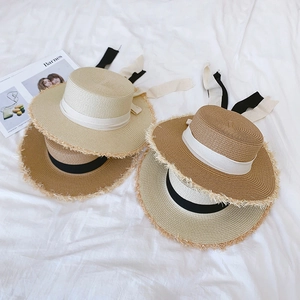 French flat top raffia sun hat with frayed edges and elegant ribbon bow detail