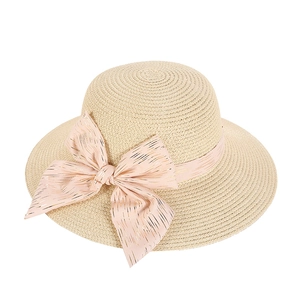Women's straw sun hat with large pink bow and wide brim for summer beach sun protection
