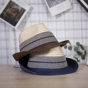 Close-up of woven straw fedoras featuring stylish striped bands on a light wooden surface
