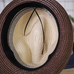 Detail of woven straw fedora interior showing black sweatband and adjustable drawstring