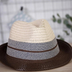 Detail of three-tone straw fedora hat featuring woven texture and brim detail
