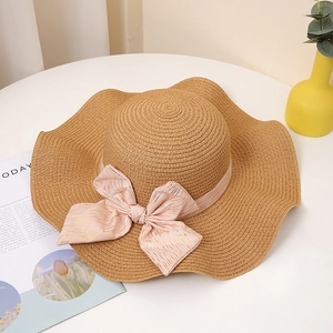 Chapeau de paille d'été à larges bords ondulés avec un grand nœud rose pour femme