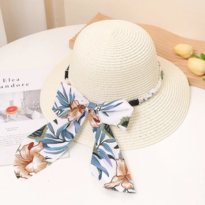 Gros plan détaillé du chapeau de paille avec ruban floral et accents de perles