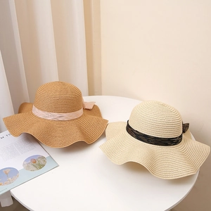Chapeau de soleil en paille pour femme avec nœud élégant et large bord ondulé de plage