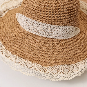Detailed close-up of woven straw hat texture with elegant white crochet lace trim