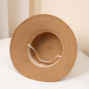 Détail intérieur d'un chapeau de paille tressé avec mentonnière élastique blanche
