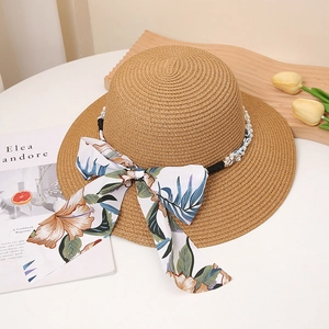 Détail de chapeau de paille avec perles blanches et ruban à motif floral orange