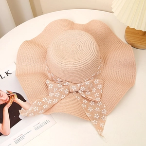 Summer wide brim straw sun hat with floral ribbon bow and wavy edge for beach travel
