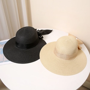 Elegant wide-brim straw sun hats in black and beige with bow ribbons for sun protection
