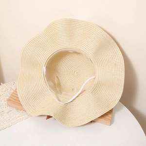 Detail of wide brim straw sun hat featuring wavy edges and adjustable windproof strap