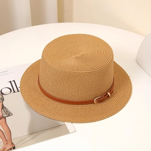 Détail d'un chapeau de paille à bord plat avec ruban en cuir brun et boucle en métal