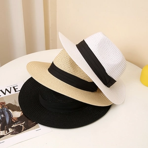 Straw boater hats in black, beige, and white with black ribbon bands on white table