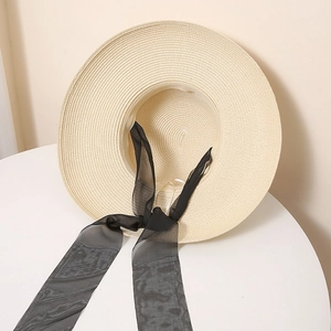 Gros plan détaillé sur la texture de la paille et le ruban noir élégant du chapeau de soleil