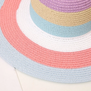 Close-up of rainbow striped sun hat showing detailed multicolored straw weaving texture