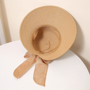 Detail view of woven straw hat with wide brim and elegant oversized linen bow decoration
