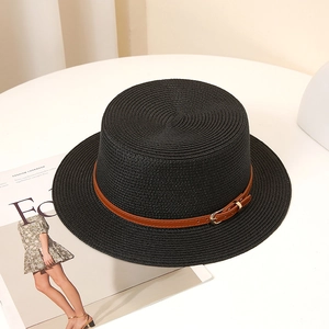 Vue détaillée d'un chapeau de paille noir avec texture et lanière en cuir brun