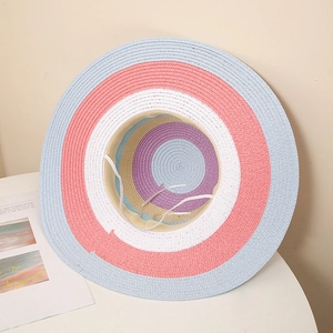 Close-up of colorful rainbow straw sun hat showing striped weave texture and wide brim