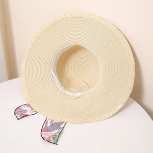 Detailed texture of the wide-brimmed straw hat with tropical print ribbon