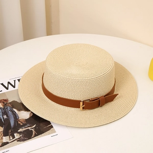 Close-up of a stylish boater straw hat with brown faux leather belt and gold buckle