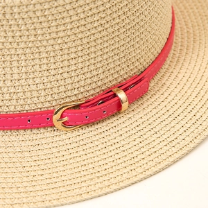 Vue détaillée du tressage en paille avec bande en cuir rose et boucle en métal doré