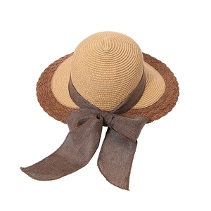 Elegant two-tone straw sun hat featuring a wide brim and decorative brown ribbon bow