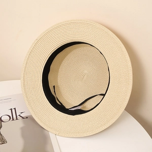 Gros plan de l'intérieur d'un chapeau de paille avec bandeau et étiquette de lavage