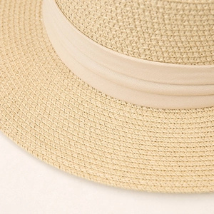 Detail of fine-woven beige straw hat with matching fabric band for summer sun protection