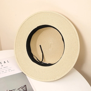 Detail view of woven straw hat interior with black sweatband and adjustable drawstring