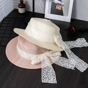 Women's summer straw hat with wide brim, lace ribbons and flat top in white and pink