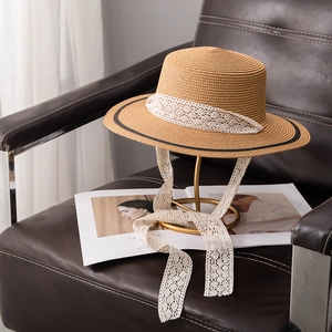 Détail d'un chapeau de paille rétro à bord noir avec un ruban de dentelle blanche élégant