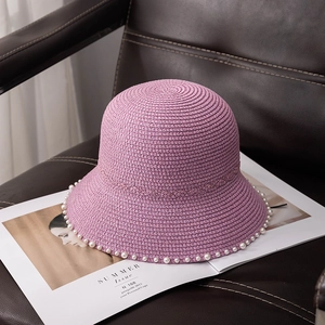 Elegant light purple straw sun hat with pearl trim on a stylish fashion magazine