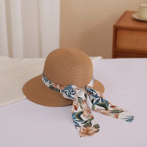 Brown woven straw sun hat with floral ribbon and bow for beach vacation protection