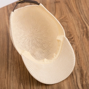 Detailed close-up of straw baseball cap with leather adjustable buckle strap and sweatband