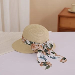Close-up of woven straw sun hat featuring a floral ribbon bow and elegant texture