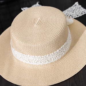 Detailed close-up of woven natural straw texture and delicate white lace on boater hat